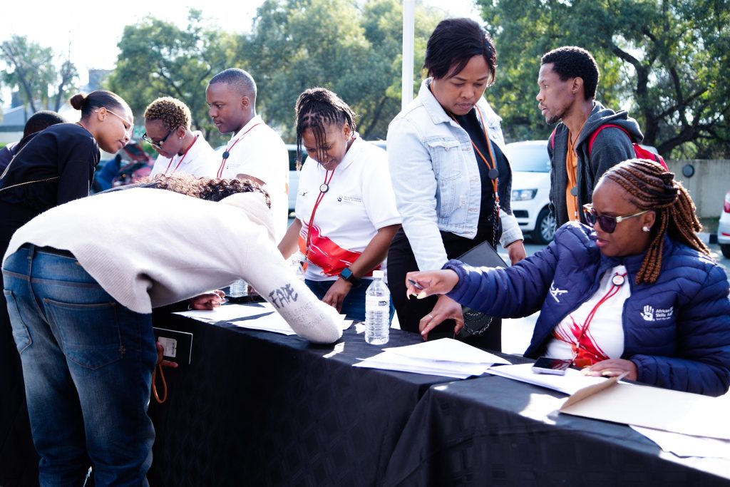 Attendees being assisted at the registration area during the To The Power of X² North West launch in Mahikeng.